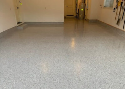 The image shows a garage with flake epoxy flooring installed