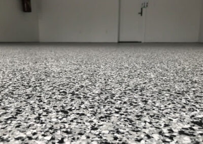 The image shows a garage with flake epoxy flooring installed