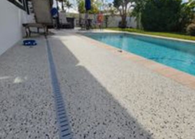 The image shows a newly resurfaced pool deck